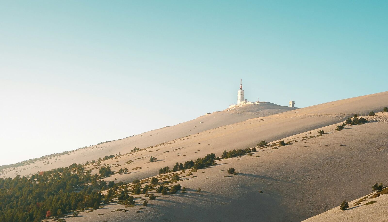 The bare slopes of Mont Ventoux and the summit observatory under a blue sky