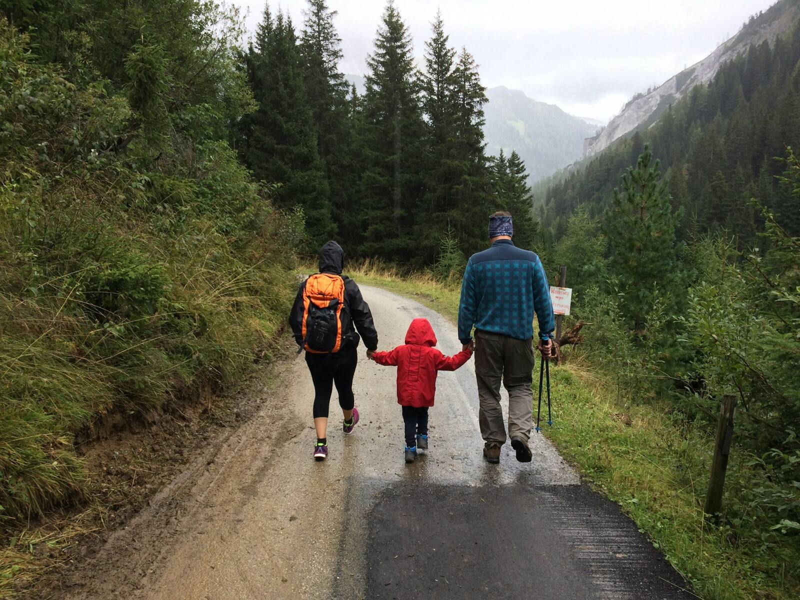 Eltern mit ihrem Kind beim Wandern auf einem Bergweg