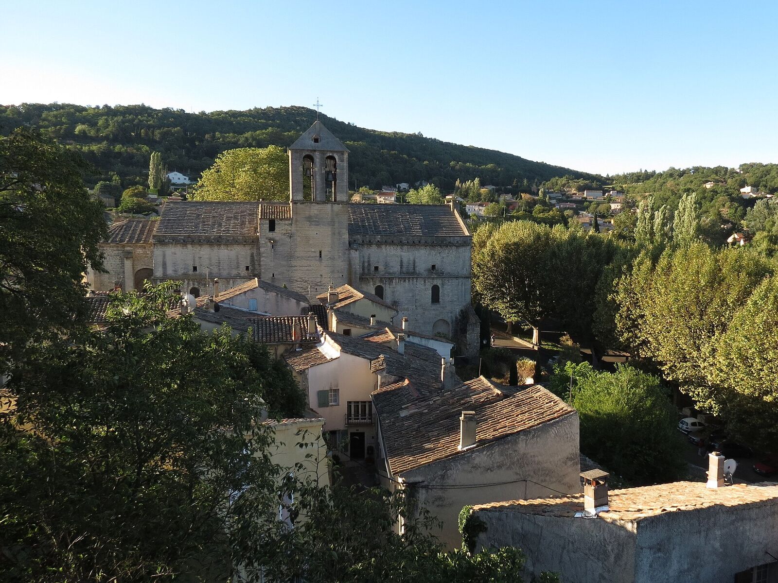 Malaucène, its tiled roofs and the bell tower of Saint-Michel church, at the foot of the hills